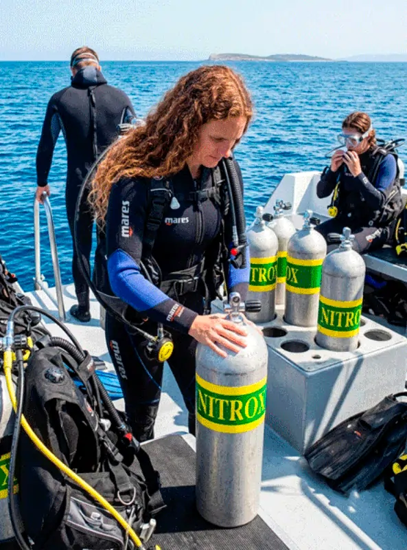 Instructor y buceadora revisando equipo antes de un dive con Nitrox